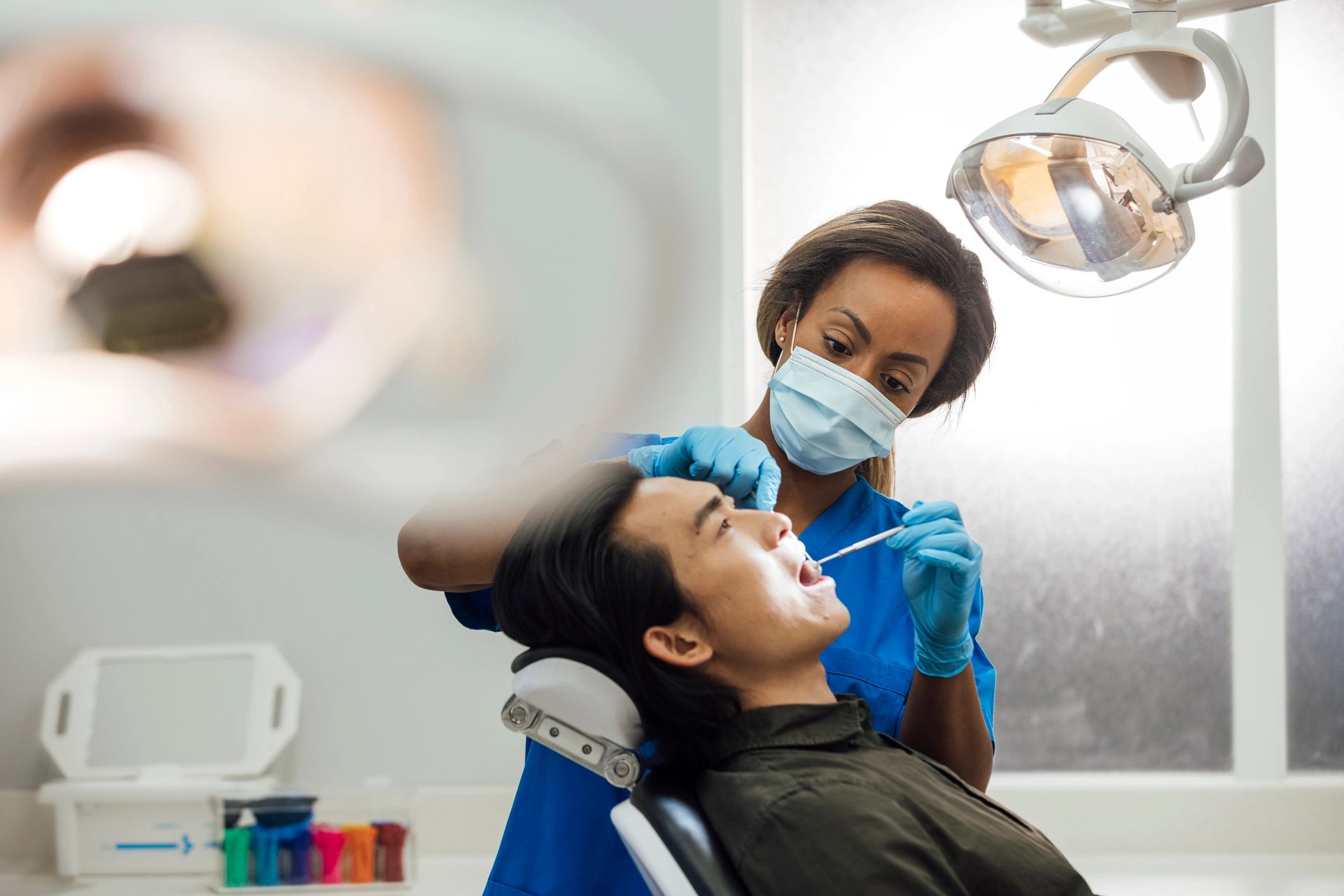 Asian dental professional performing a preventive checkup for a patient