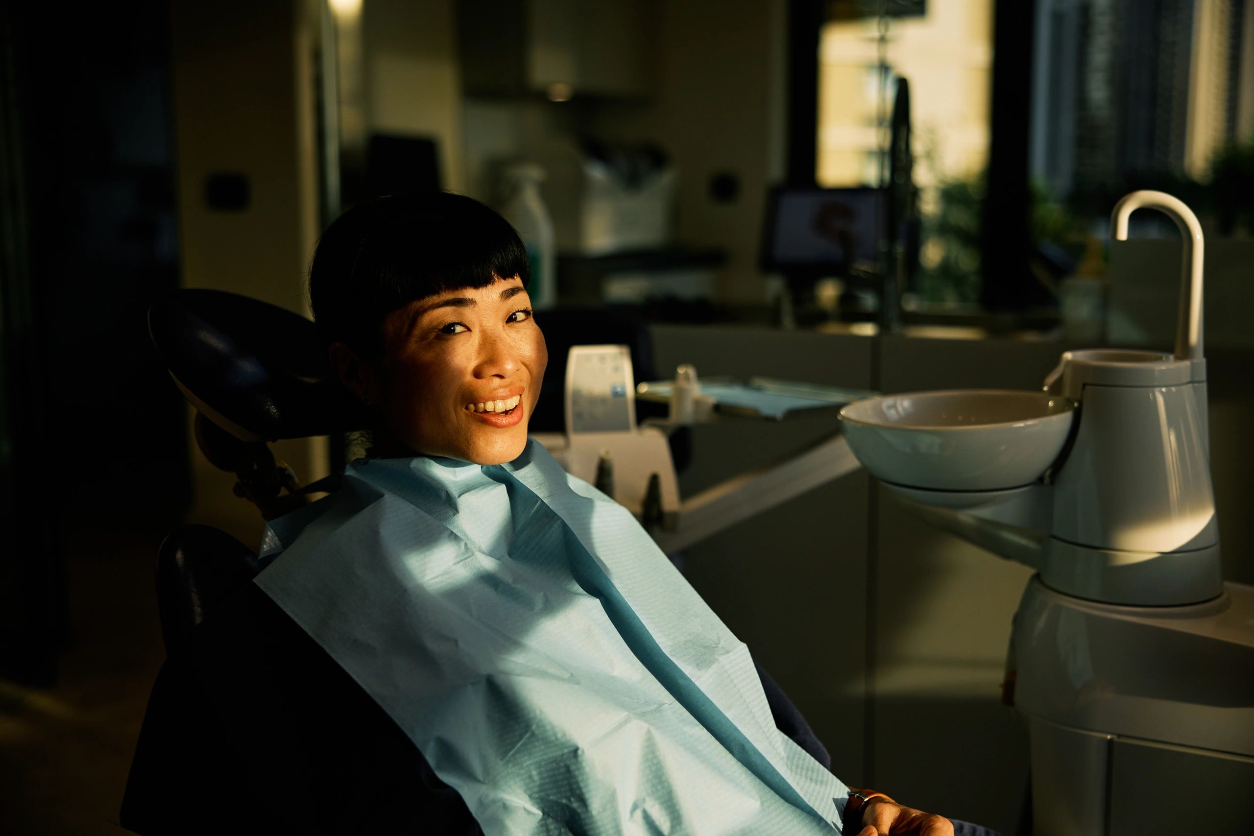 Asian female dental patient smiling after treatment