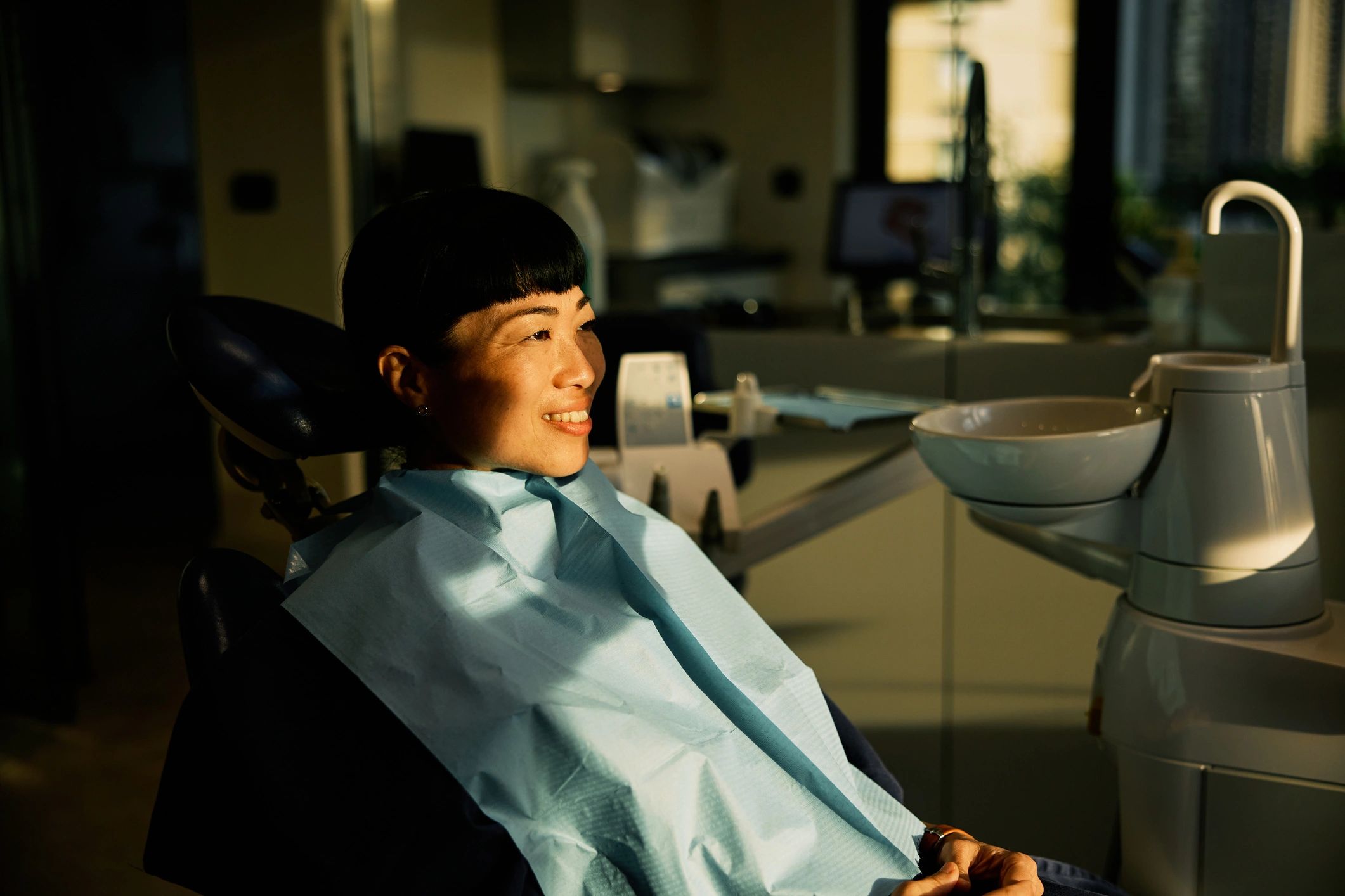 Asian female patient smiling in a dental chair